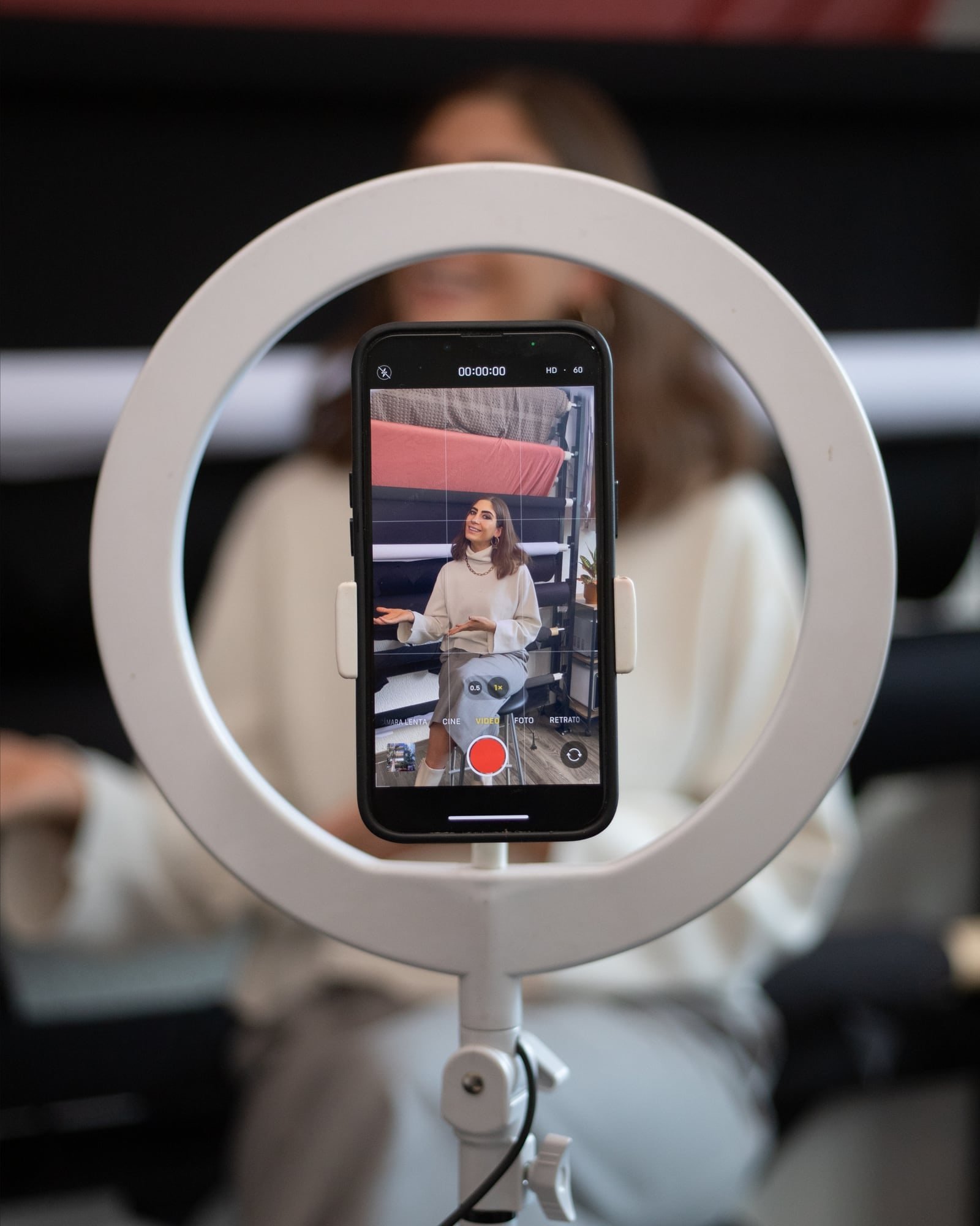 Aro de luz con un celular grabando a una creadora de contenido